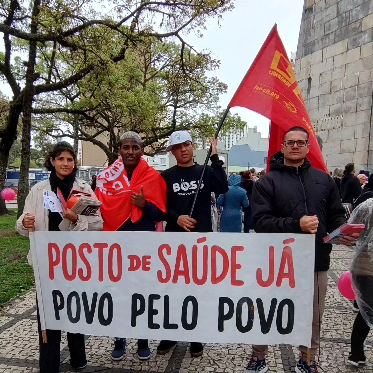 Jean Henrique e militantes segurando uma faixa em defesa de posto de saúde