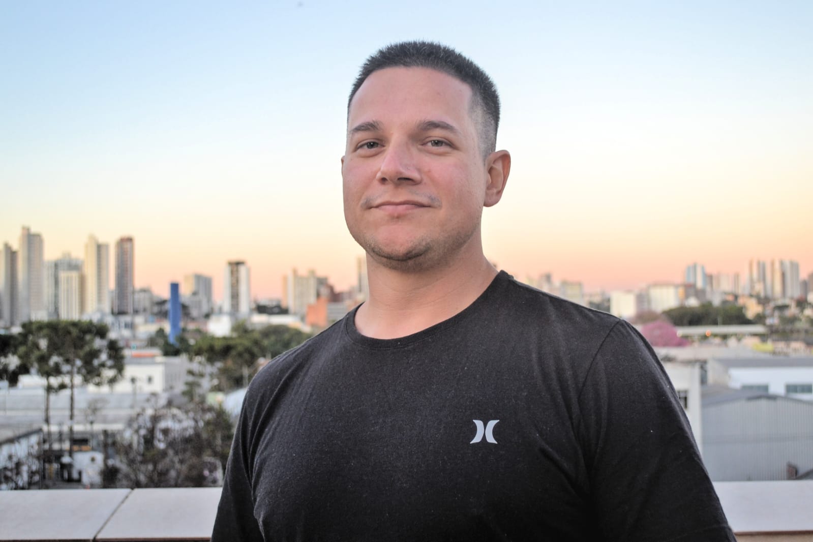 Jean Henrique com a cidade ao fundo no fim da tarde